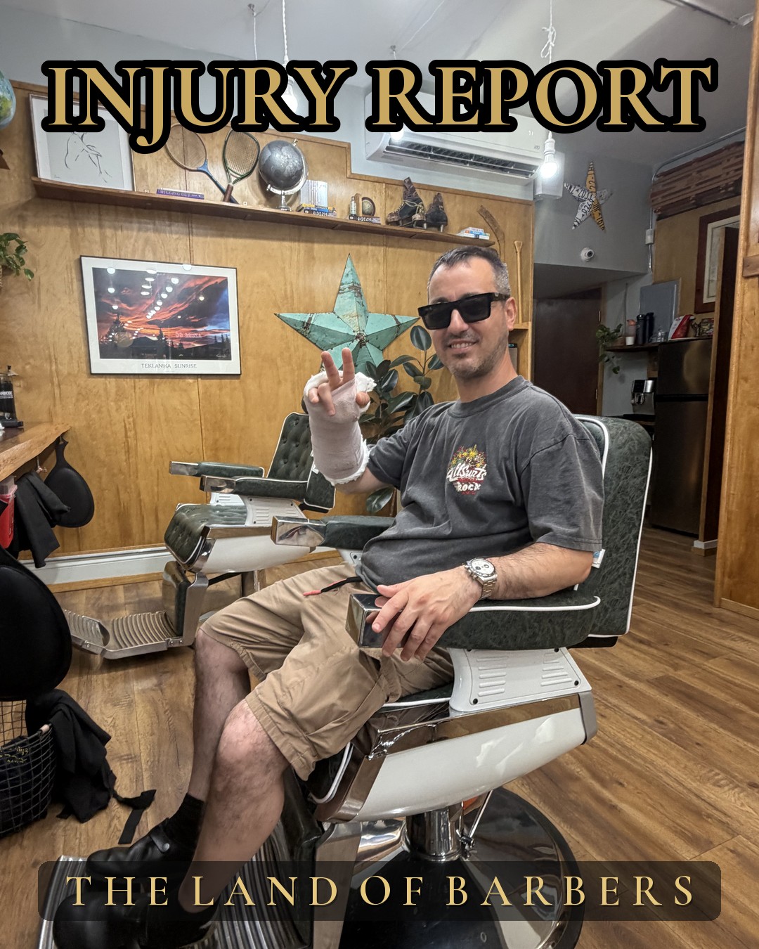 Ivano, arm bandaged, peace sign from the barber chair — Land of Barbers Greenpoint